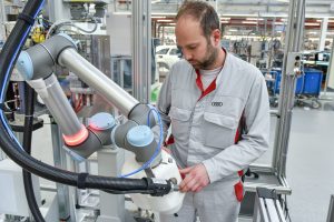 Human-robot cooperation in the assembly of Audi-A4/A5 models: “Adhesive application with robot assistance,” abbreviated from the German as KLARA, provides support to the employees with the installation of large CFRP roofs in the new Audi RS 5 Coupe (fuel consumption combined in l/100 km: 8.7; CO2 emissions combined in g/km: 197). Due to the integrated sensors, KLARA does not require a protective fence between man and machine. The robot recognizes when a machine is touched by a human and automatically stops if there is any danger. KLARA also indicates any disturbance with its illuminated ring, which then lights up red, thus helping to keep the working space safe.